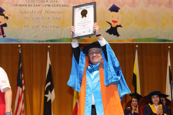Dr. Lim Teck Ting holds up the certificate of Malaysian Book of Records